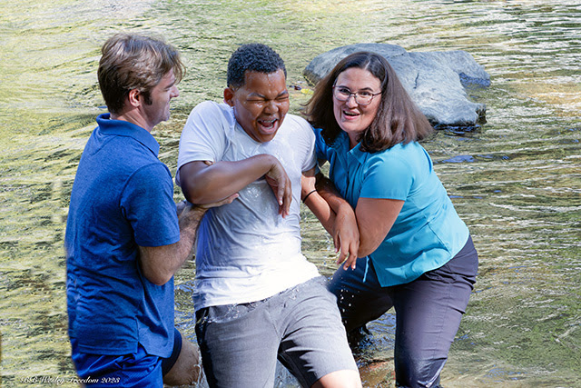 The Rev. Jenny Smith (right) and Director of Youth Ministries, Tim McKenzie (left) baptize a young person at Patapsco River in Eldersburg, Md., on Oct. 1. Photo by Brenda Bowman, Wesley Freedom United Methodist Church.    