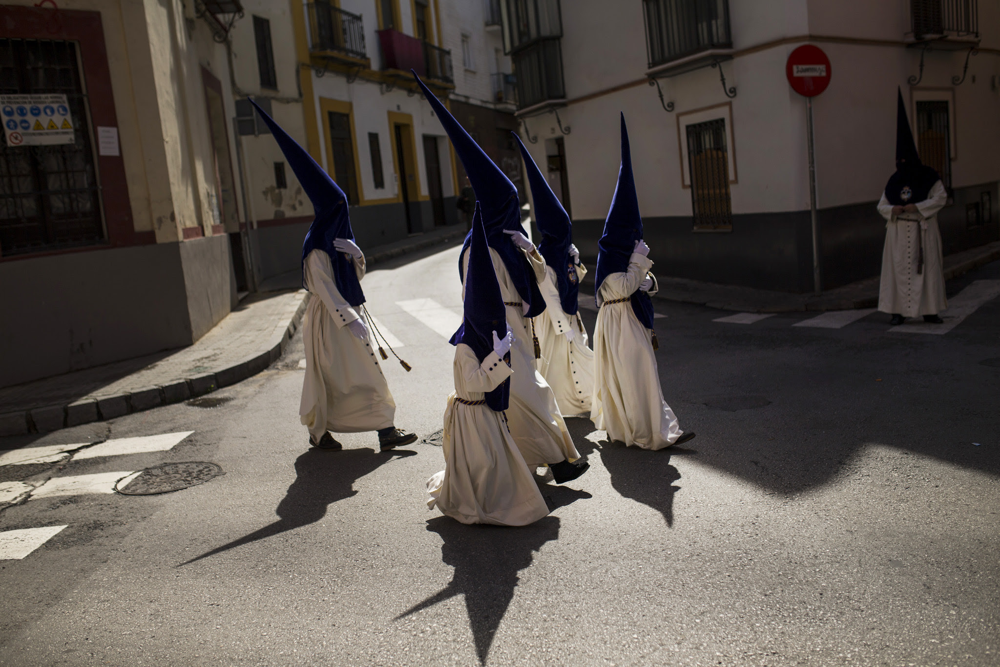 Hooded penitents from the "El beso de Judas" brotherhood walk to the church to take part in a traditional annual procession in Seville, Spain, Monday, March 21, 2016. Hundreds of processions take place throughout Spain during the Easter Holy Week. (AP Photo/Francisco Seco)