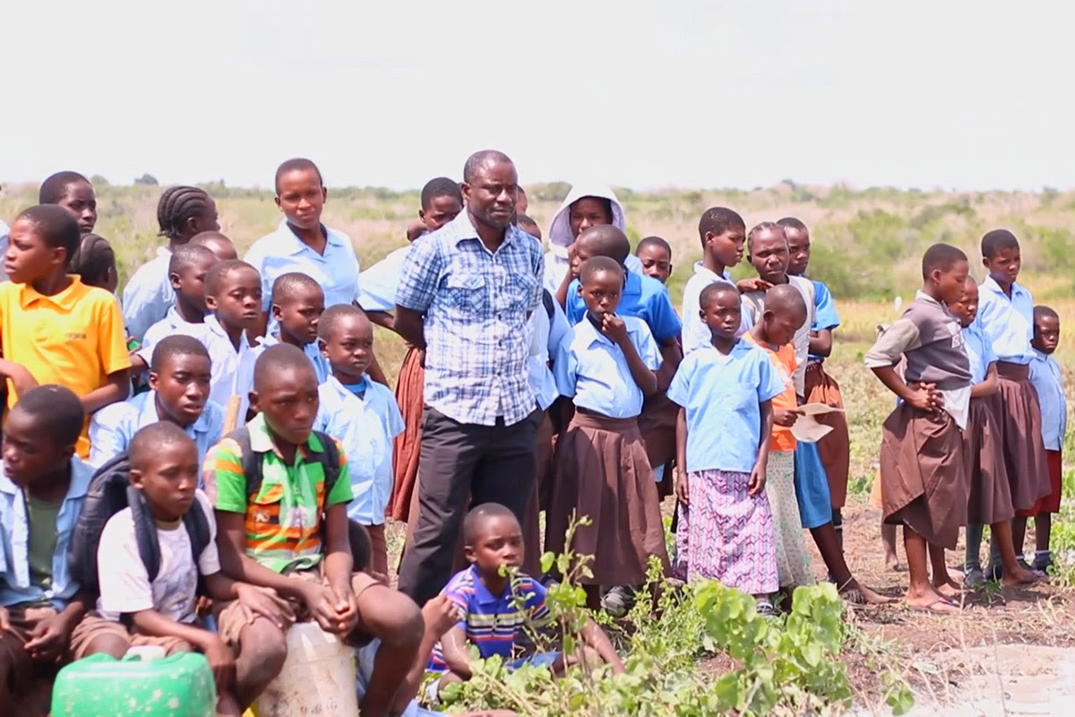 Photo of Emmanuel and the children he looks after at the farm.