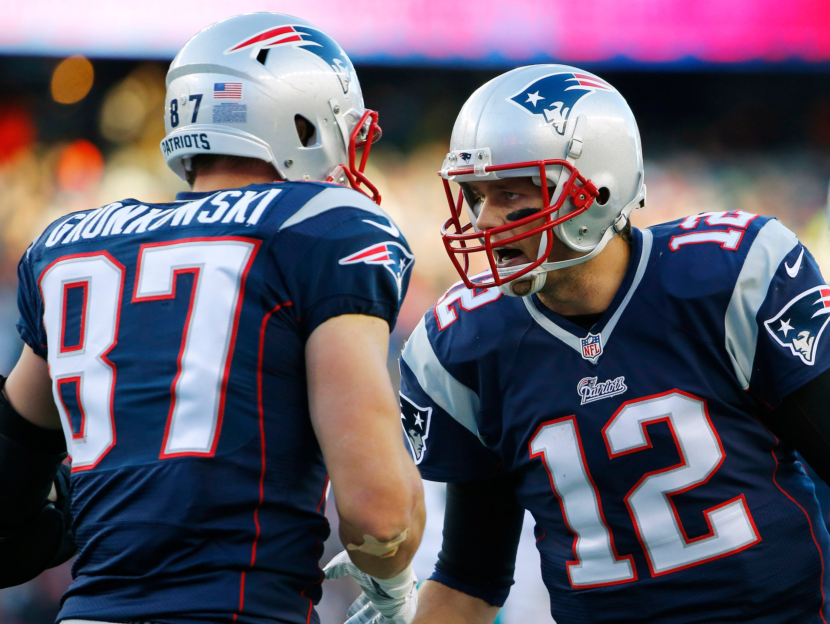 New England Patriots quarterback Tom Brady (12) celebrates with tight end Rob Gronkowski (87) after catching the ball to score a touchdown during the second half against the Miami Dolphins at Gillette Stadium.