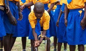 Unos niños lavándose las manos en un depósito de agua instalado en su escuela primaria en el noreste de Uganda.