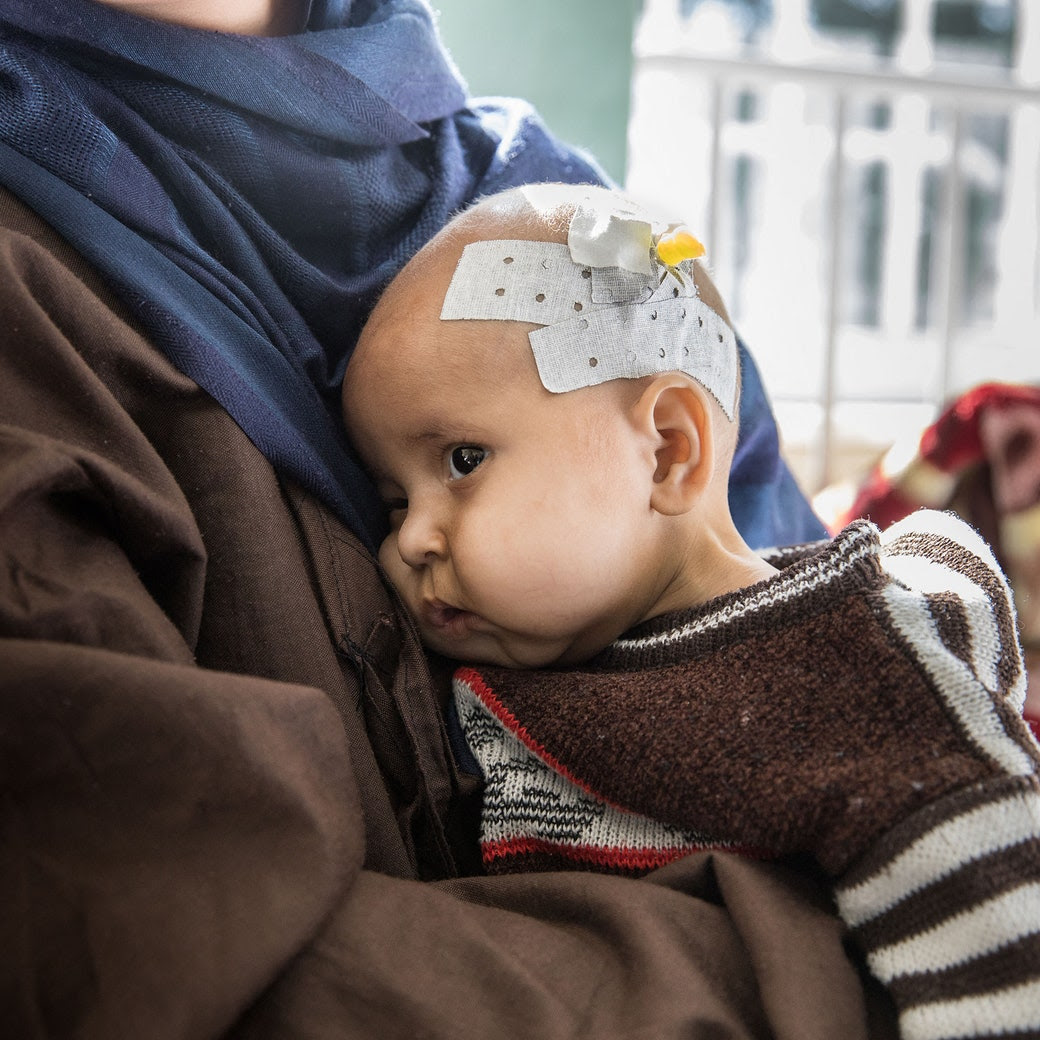 A woman carries a baby.