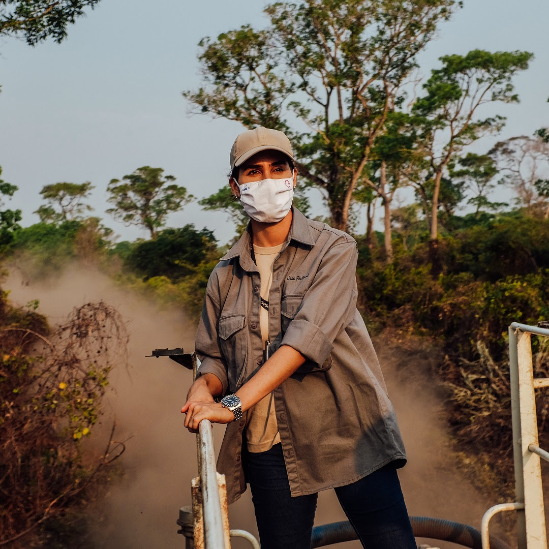 Cristina Cuiabália stands on top of a water truck riding through the Pantanal wetlands