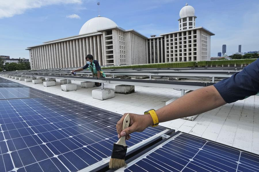 Workers perform maintenance work on solar panels that provide partial electrical power to Istiqlal Mosque in Jakarta, Indonesia.
