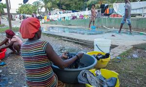 Una mujer desplazada por la violencia en la capital haitiana, Puerto Príncipe, lavando la ropa en un parque de la ciudad.