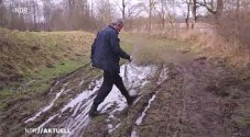 Quarnbek policeman wading in the Kiel canal bank mud / Photo credit: NDR