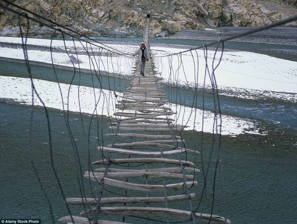 One way of getting across                                                           the Hunza                                                           River in the                                                           Karakoram                                                           Mountains of                                                           Pakistan is by                                                           the rickety                                                           Hussaini                                                           bridge, which                                                           consists of                                                           various pieces                                                           of wood                                                           strapped                                                           horizontally