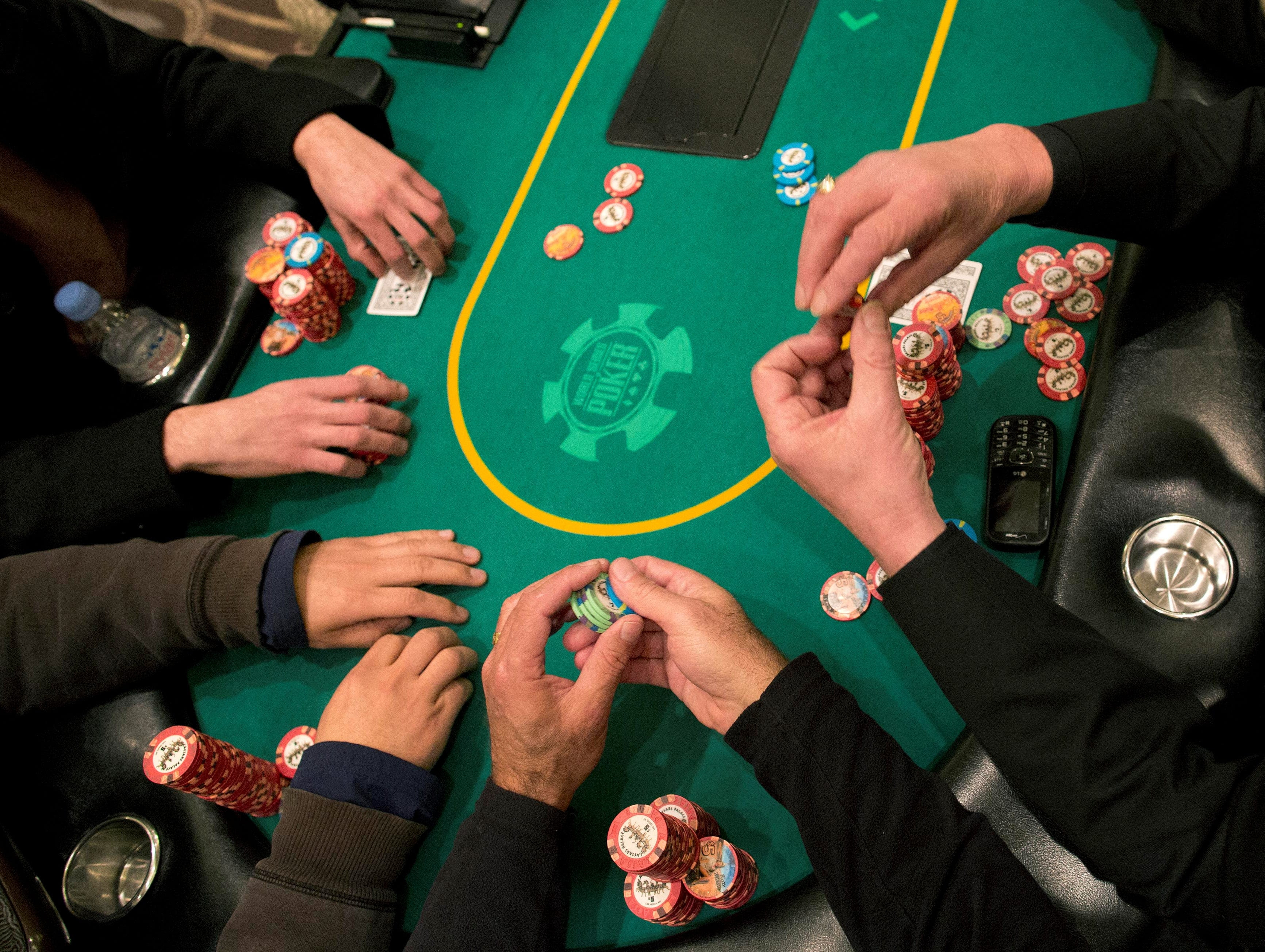 Poker players cast their bets during a hand of Texas Hold 'em at the poker room at Caesar's Palace.