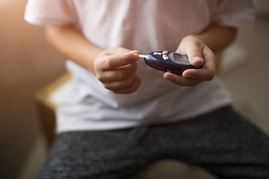 Young adult testing his blood sugar.