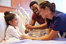 photo of a child in a hospital bed with a parent and physician