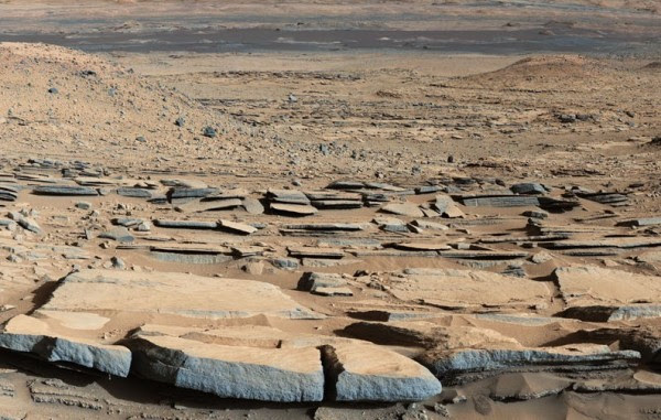 Strata rocks and dark sand in an area that has been named 