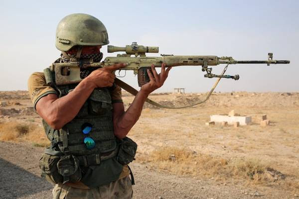 A Russian soldier looking through the scope of a sniper rifle during a Russian Defense Ministry media tour on the outskirts of Deir al-Zour on Sept. 17. (Dominique Derda/Agence France-Presse via Getty Images)