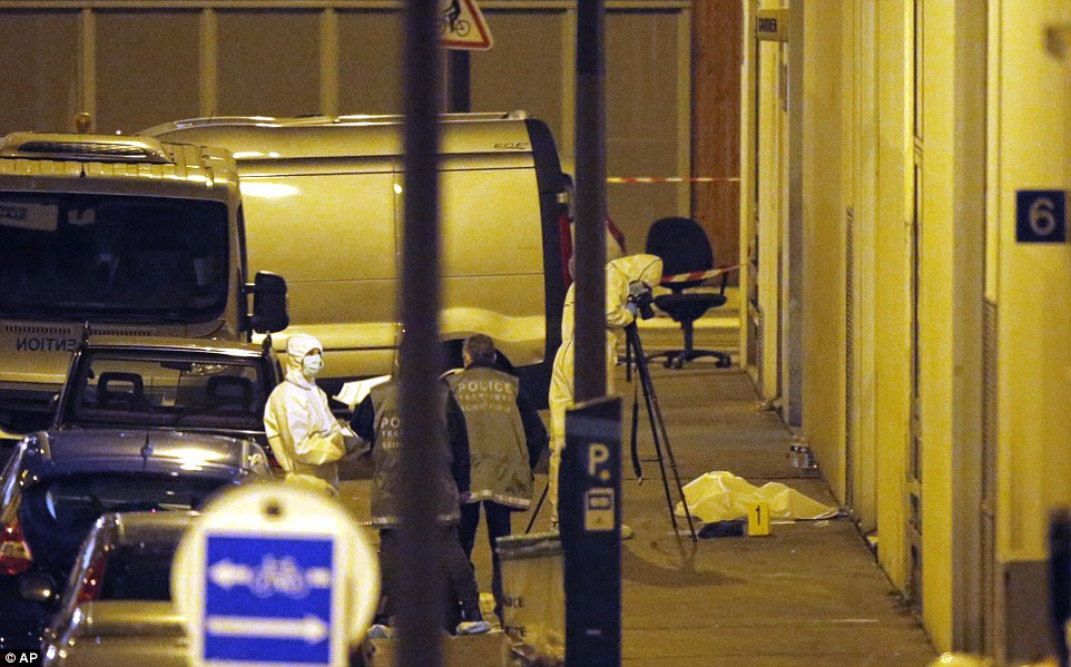 Tonight: French forensic experts and police officers examine evidence outside the French satirical newspaper Charlie Hebdo's office, in Paris