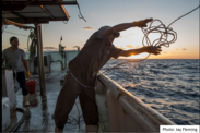 fisherman casting a line over the boat edge