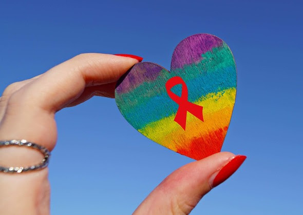 Hand Holding Painted Heart With Red HIV Ribbon