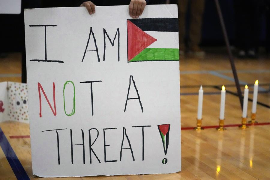 A sign with the Palestinian flag on it and text that says, 'I am not a threat!'