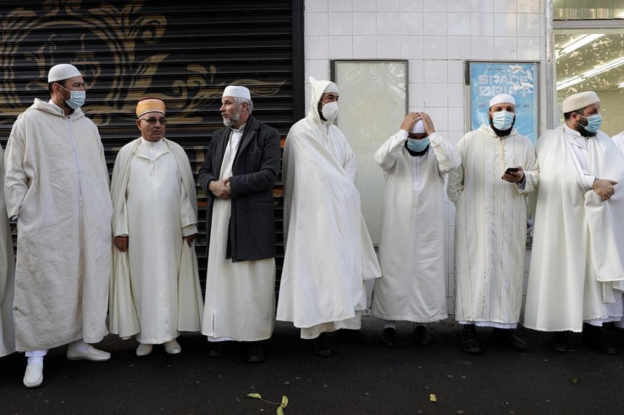 Imams from Paris mosques gather before paying their respects to the victims of the Nov. 13, 2015 attacks, near the Bataclan concert hall in Paris, Friday, Nov. 12, 2021, on the eve of the sixth anniversary of the attacks. Fourteen men are currently on trial over the Nov. 13, 2015, Islamic State attacks in Paris that killed 130 people. (AP Photo/Adrienne Surprenant)