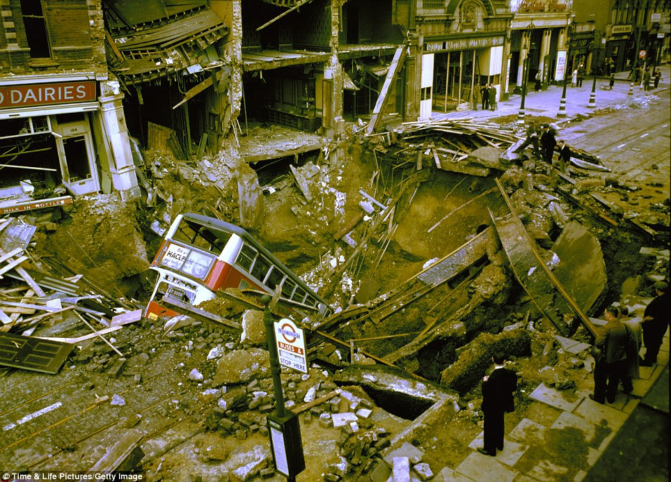 High-street terror: The incredible destruction of the Blitz is revealed in this image as a double decker bus is plunged into a bombed crater