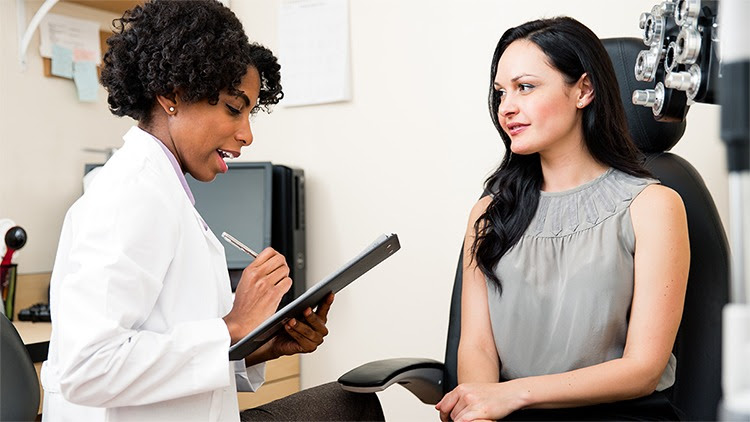 The figure shows a patient consulting with an eye care provider during an examination.