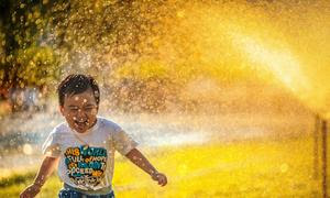 Un niño se refresca jugando con agua en Viet Nam