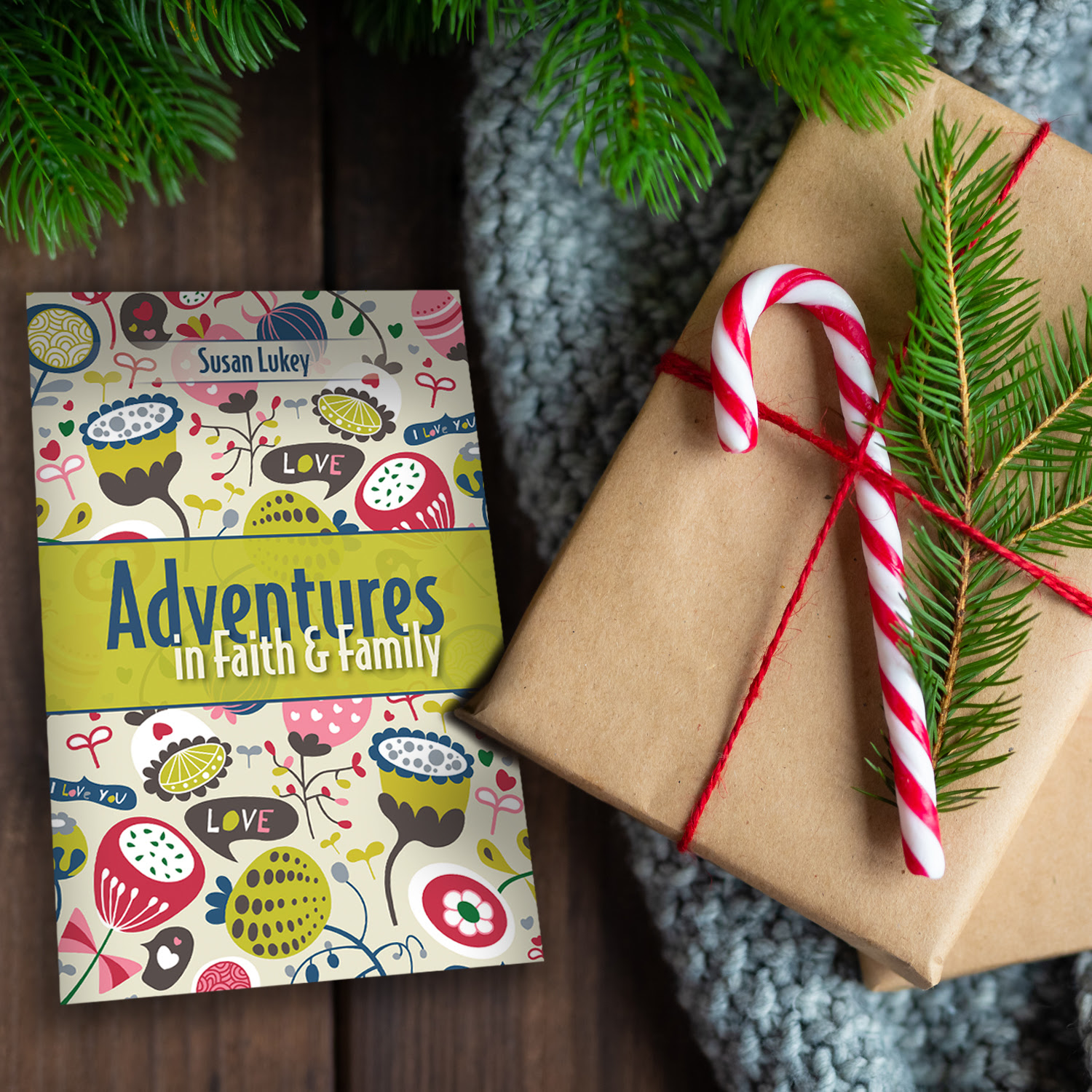 Bird's eye photo of the  book, next to a present wrapped in brown paper and red string, with a candy cane and pine twig.