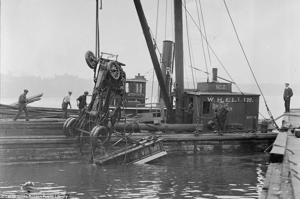 The shell of a truck is pulled from the Charles River after it careered off the Harvard Bridge