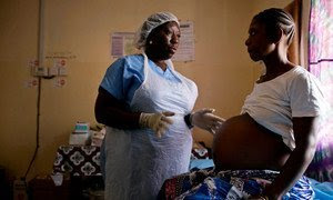 Una comadrona examina a una mujer embarazada en Sierra Leona. 
