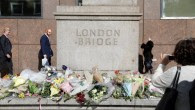 People walk past flowers laid out south of London Bridge in London, for the victims of the June 3 terror attack on the bridge and at  Borough Market,  June 6, 2017. (AFP/Odd Andersen)