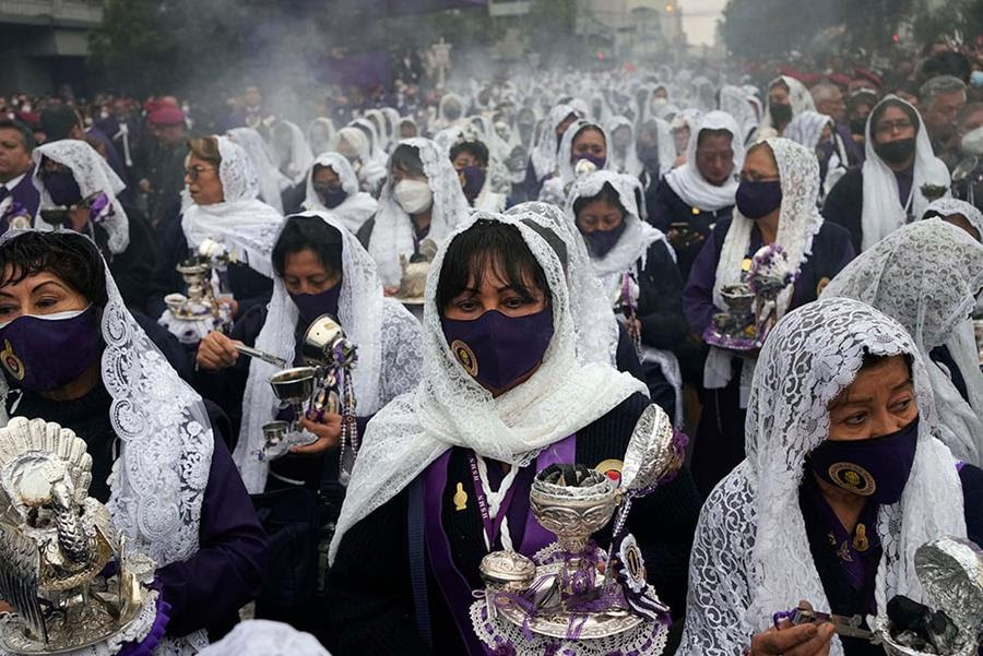 Woman wearing white veils and carrying burning incense take part in a procession marking the Lord of Miracles feast day in Lima, Peru.