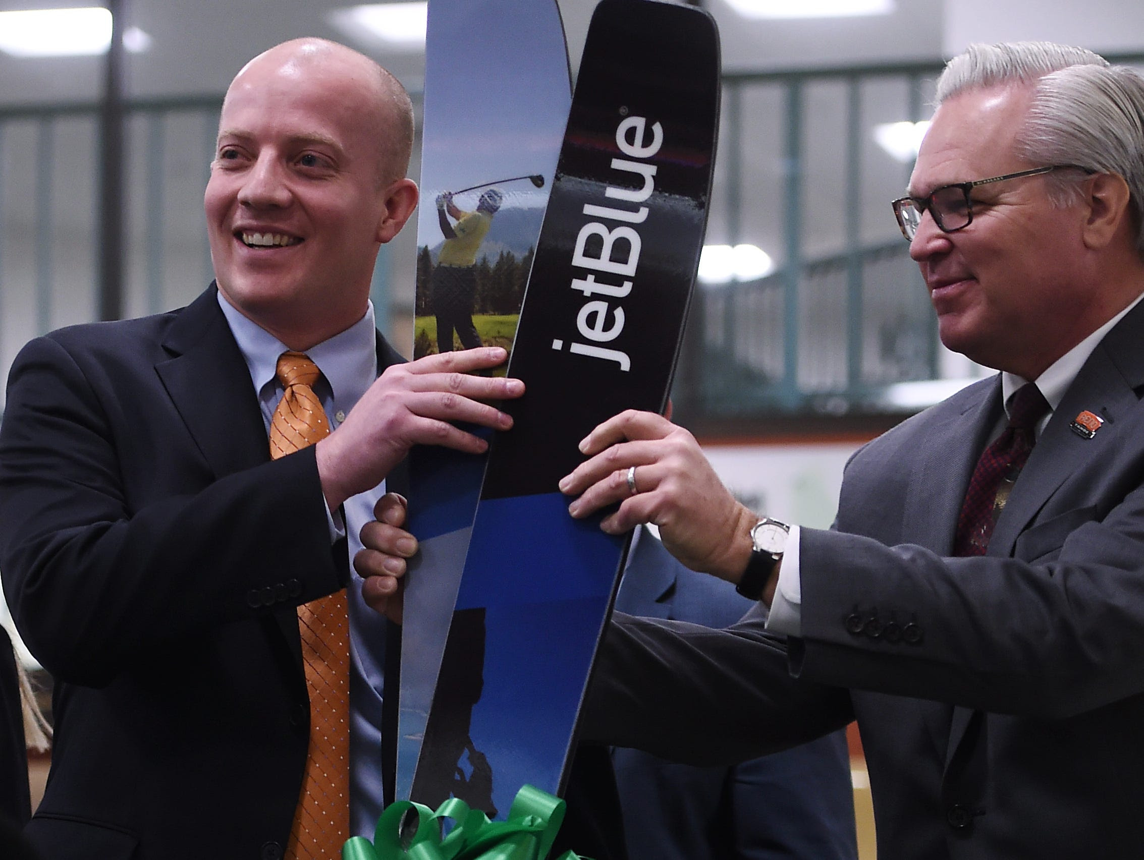 Director of Route Planning for Jet Blue Airlines John Checketts, left, is presented with a pair of custom Moment Skis by Christopher Baum, President of the Reno-Sparks Convention and Visitor Authority, during a press conference at the Reno-Tahoe Inte