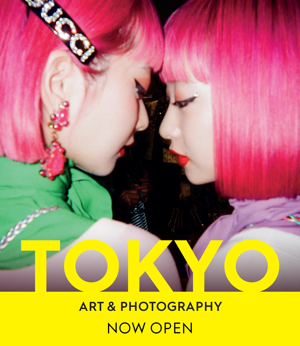 Tokyo exhibition title, and photograph of two women with short pink hair facing each other