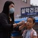 A teacher took a student's temperature in Seoul on Monday.