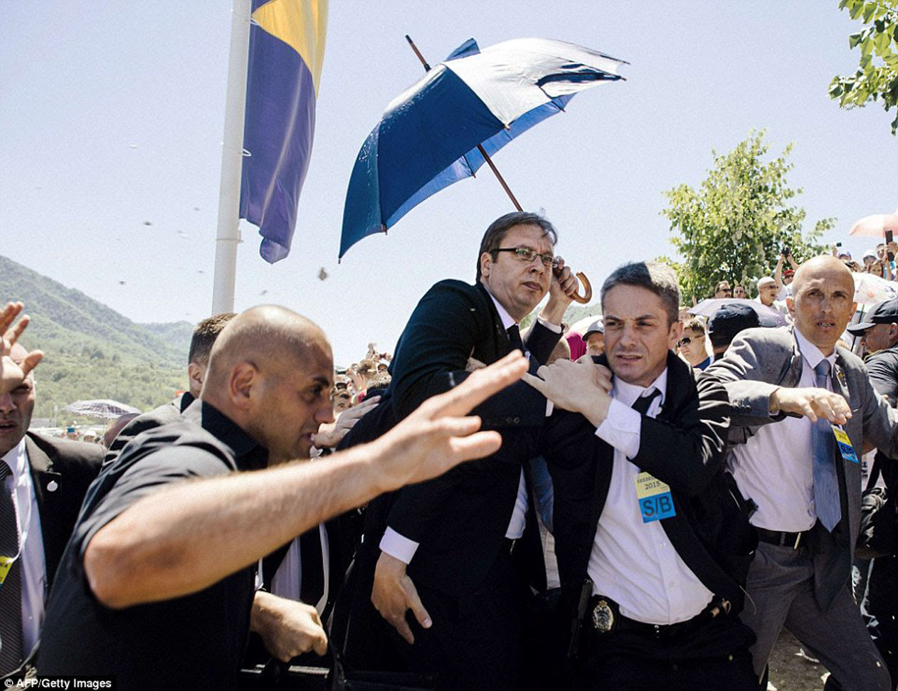 Serbia's Prime Minister Aleksandar Vucic (Centre) Whisked Away From Srebrenica, Bosnia, Mourning Graveyard Amidst Pelting Of Stones And Bottles Against Him Saturday 11 July 2015 Photo: AFP/Getty Images  