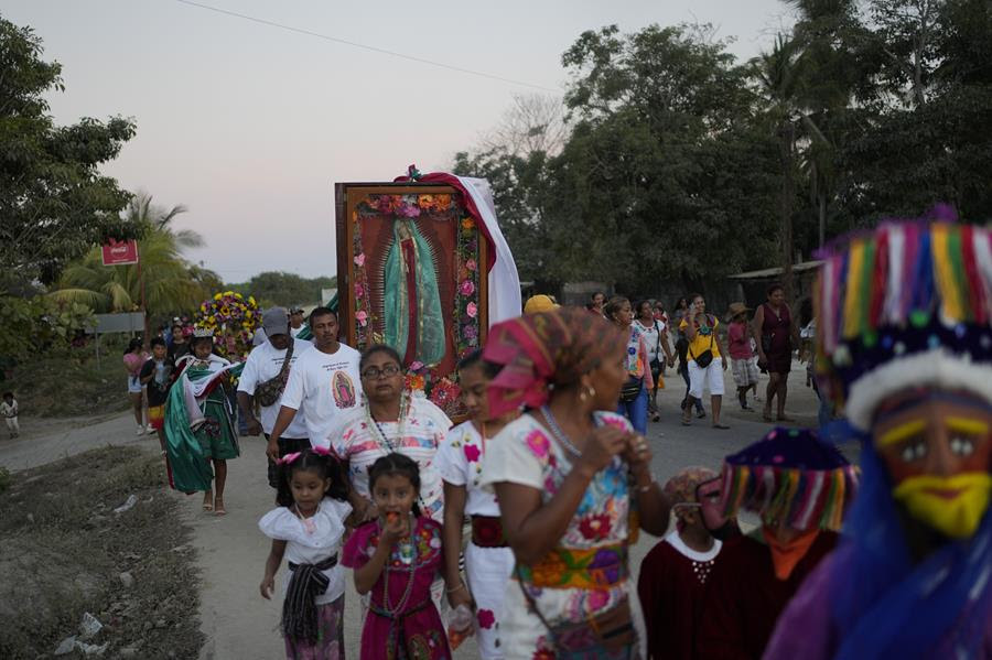 A procession of people participating in the Virgin of Guadelupe pilgrimage.