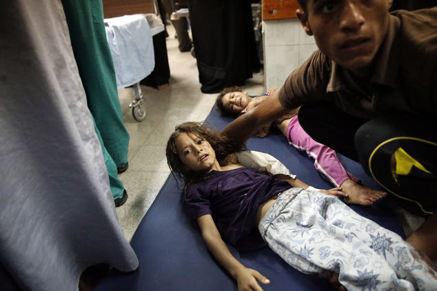 Palestinian children, wounded in an Israeli strike on a compound housing a U.N. school in Beit Hanoun, in the northern Gaza Strip, lay on the floor of an eme...