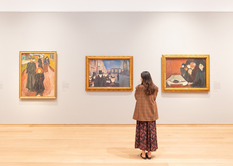 A photo of a woman looking at art in the Edvard Munch. Masterpieces from Bergen exhibition.