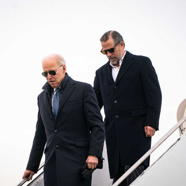 President Biden and his son Hunter Biden, both wearing sunglasses and dark overcoat as they descend stairs from an airplane.