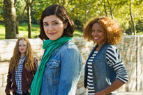 Three women standing together in a park