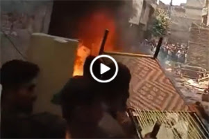 Video link: A fire in the riots; a piece of furniture is being thrown into the fire.