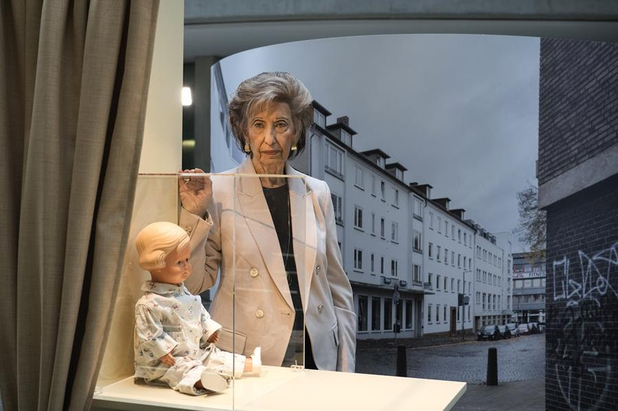 locaust survivor Lore Mayerfeld poses next to her doll 'Inge' as part of an exhibition with items from Israel's Yad Vashem Holocaust memorial in the German parliament Bundestag in Berlin, Germany.