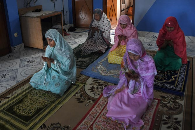 Family members offer a special prayer in their home during Eid-al-Fitr, which marks the end of Islamic holy fasting month of Ramadan.