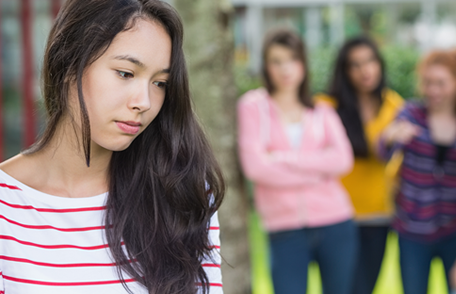 A teenage girl being taunted by a group of other teens