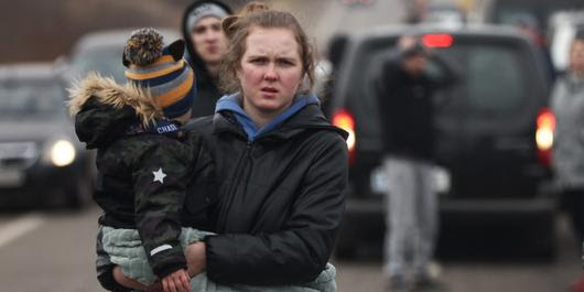 Une femme qui porte son enfant fuit la guerre en Ukraine, à 26 km de  la Pologne. Le 27 février 2022.