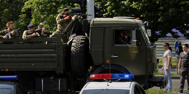 Prorrusos armados cruzan un checkpoint policial camino del aeropuerto de Donetsk en un camión militar. Lunes 26/05/2014. REUTERS/Yannis Behrakis