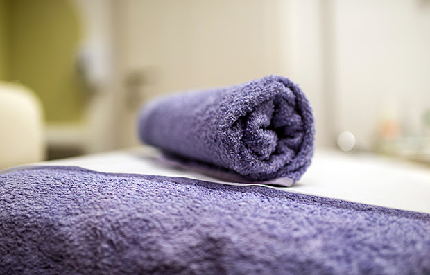 A rolled up towel on top of a massage table.