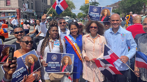 Solano holds up a Dominican flag proudly as he poses with elected officials at the parade on Grand Concourse.