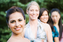 A woman smiling, with other woman in the background