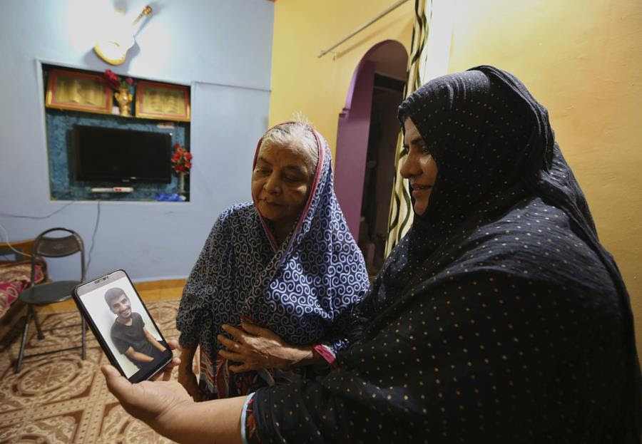 Nazima Shaikh watches with her mother a video clip of her son Arbaz Mullah at their home in Belagavi, India. (AP Photo/Aijaz Rahi)