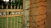 Barbed wire surrounds a pillar and gate outside the El Monte complex. 