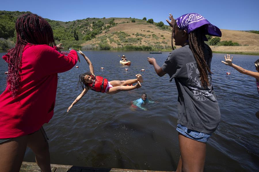 Jewish children of color enjoy time at a lake.